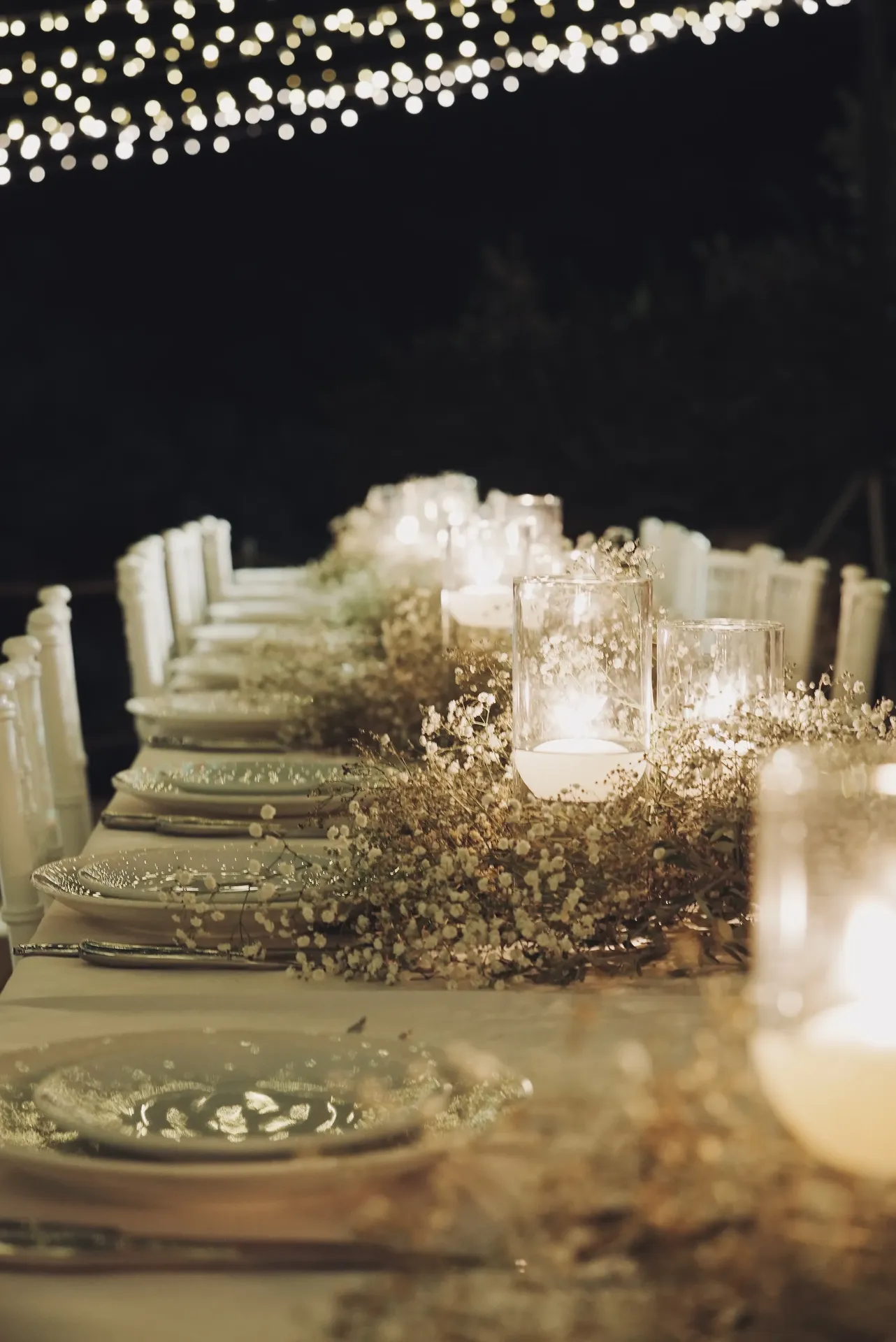 Close-up baby's breath centerpiece with candles and bokeh