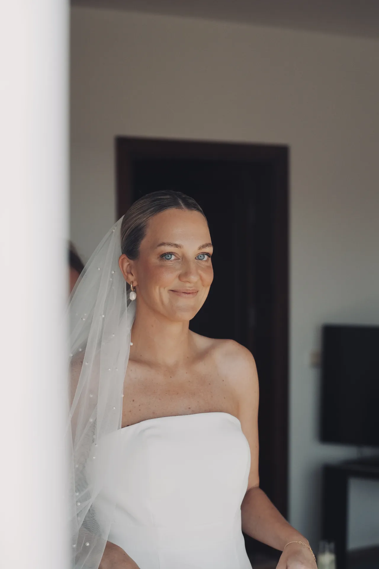 Indoor bridal portrait featuring delicate pearl-adorned veil