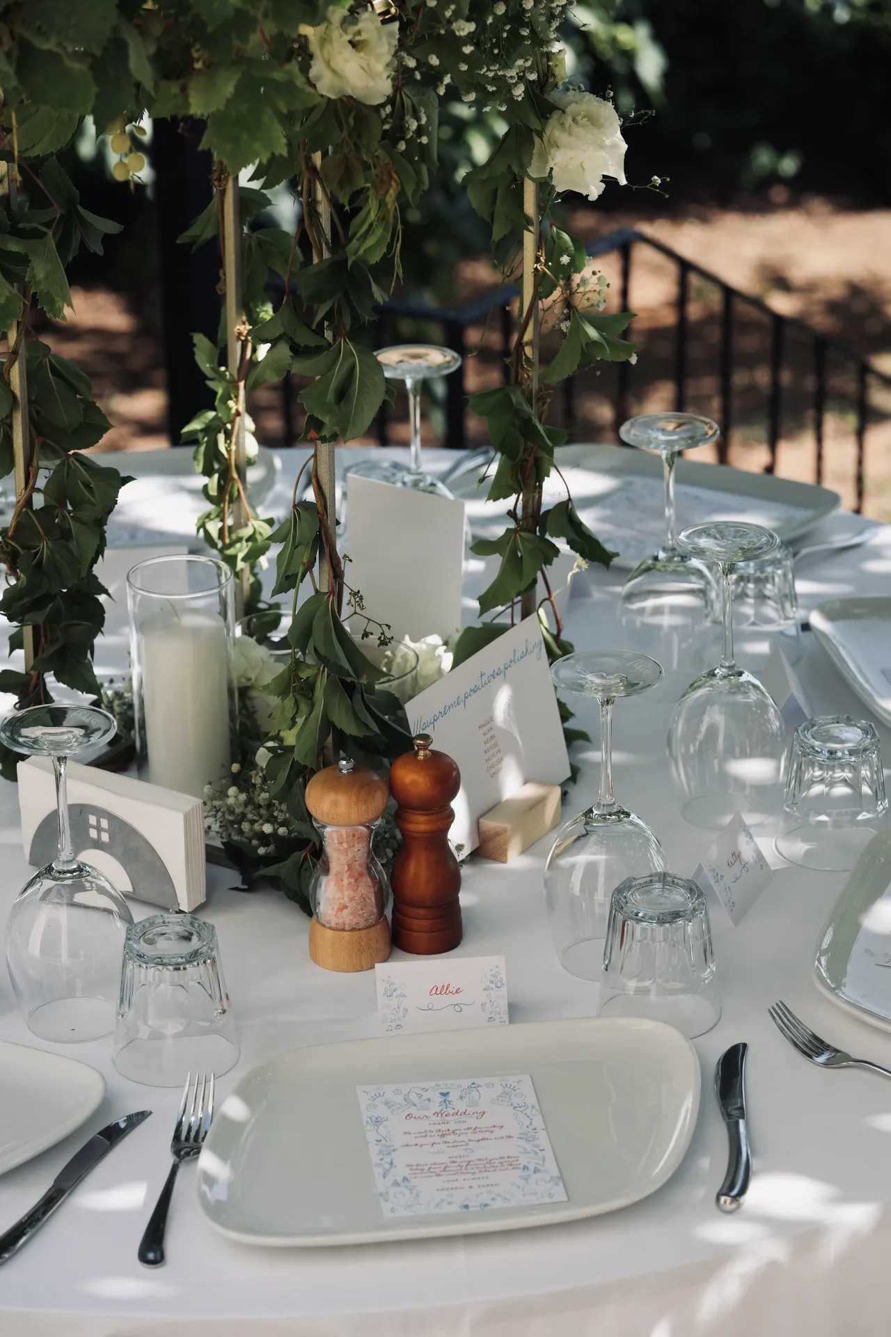 Rustic table setting with greenery centerpiece and menu cards