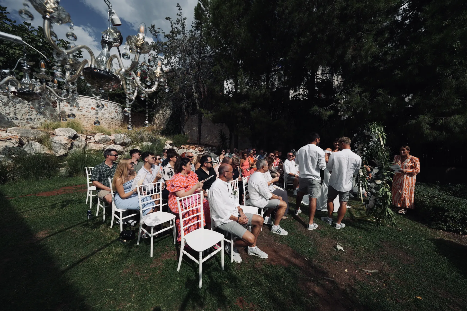 Wide view of ceremony venue with multiple suspended chandeliers